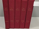 six red books are stacked on top of each other on a table