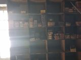 a room with a shelf full of items and a window