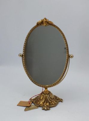 un miroir doré posé sur un pied, muni d'une étiquette