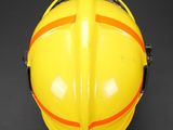 a close up of a yellow fireman ' s helmet on a black background