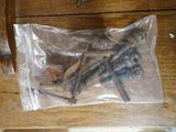 some screws are in a plastic bag on a wooden table