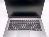 a silver laptop with a black keyboard on a white surface