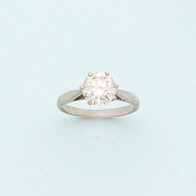 a diamond ring on a white surface with a light blue background