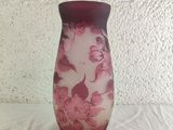 a purple vase with pink flowers on it sitting on a table