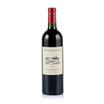 une bouteille de vin rouge posée sur une table blanche
