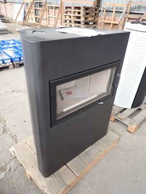 a black stove sitting on top of a pallet in a warehouse