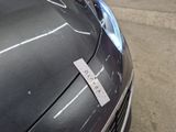 a sticker on the hood of a car that is parked in a parking lot