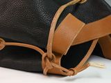 a black and brown bag with a tan strap