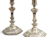 pair of silver candlesticks on a white background