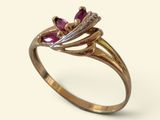 Gros plan sur une bague en or ornée de pierres roses