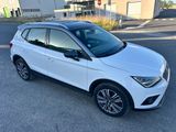 une voiture blanche garée sur le bord de la route, devant un immeuble