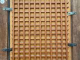 a wooden window with metal bars on the outside of it