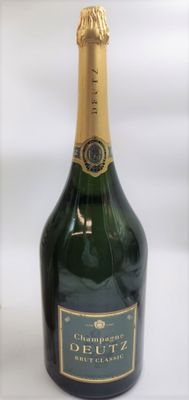 une bouteille de champagne posée sur une table blanche, sur fond blanc