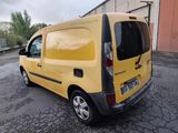 the small yellow van is parked in the parking lot