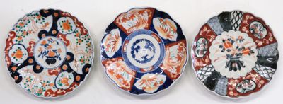 three plates with different designs on them sitting on a white surface