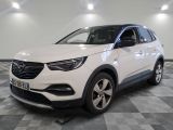 a white opel suv parked in a garage with a checkered floor