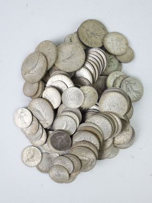 une pile de pièces d'argent posée sur une surface blanche