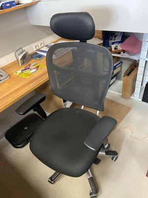 une chaise de bureau noire assise devant un bureau d'ordinateur