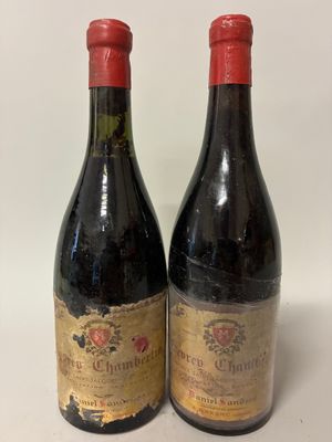 two bottles of red wine sitting next to each other on a table