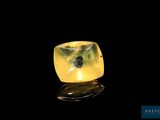 a close up of a yellow diamond on a black surface