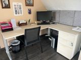 un bureau avec un ordinateur et une chaise dans un coin
