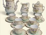 plusieurs tasses et soucoupes et une théière sur la table