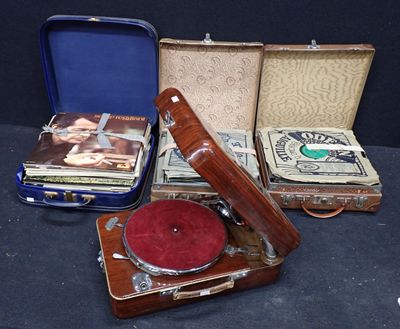 un tourne-disque posé dans une valise, à côté d'autres objets