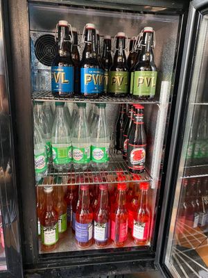 a refrigerator filled with bottles of soda and other drinks