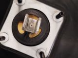 a close up of a metal object with a yellow button on it