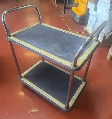 un chariot métallique muni d'une poignée, dans un entrepôt
