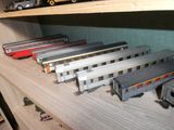 Plusieurs petits trains sont alignés sur une étagère dans une pièce
