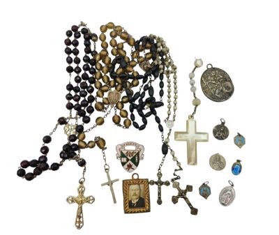 a lot of rosary and other religious items on the table
