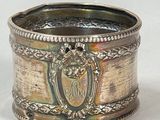 a silver ring with a crest on it on a white surface