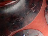 a close up of a vase with a red and black design on it
