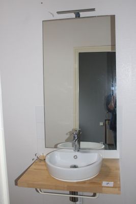 a white sink sitting under a mirror in a bathroom