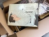 une boîte remplie de livres posée sur un lit
