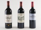 three bottles of wine are lined up on a white surface