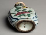 a small vase with a bird on it on a table
