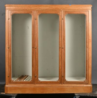 a wooden cabinet with glass doors and shelves on wheels