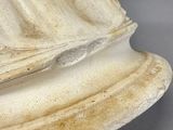 a statue of a woman sitting on top of a white pedestal