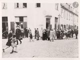 black and white photograph of a group of people walking down a street