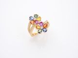 un gros plan d'une bague ornée de pierres multicolores sur un fond blanc