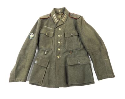 une vieille veste militaire avec un écusson sur la poitrine et un autre écusson sur la poitrine