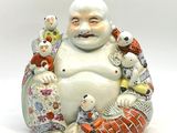 une figurine représentant un Bouddha souriant assis sur un coussin