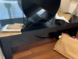 a black table with a lamp and a bag on it