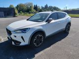 un SUV blanc garé sur un parking, avec des arbres en arrière-plan