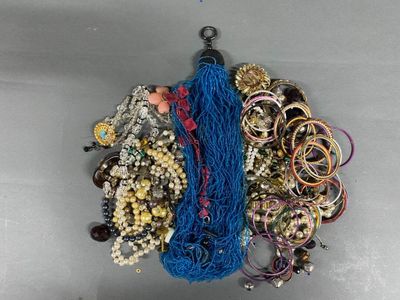 a lot of bracelets and necklaces that are on the table