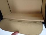 a hand that is holding a tan leather case