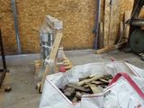 a bag of wood sitting on the floor next to a pile of wood