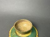 a green and yellow plate with a bowl on it